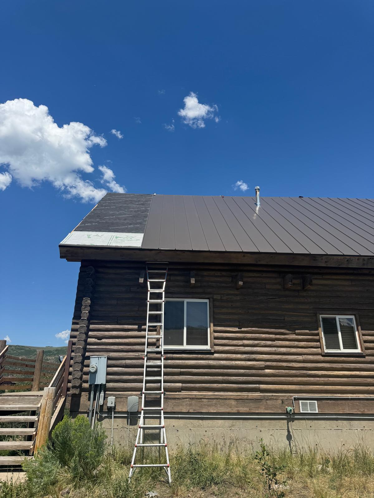 Log cabin with new metal standing seam roof