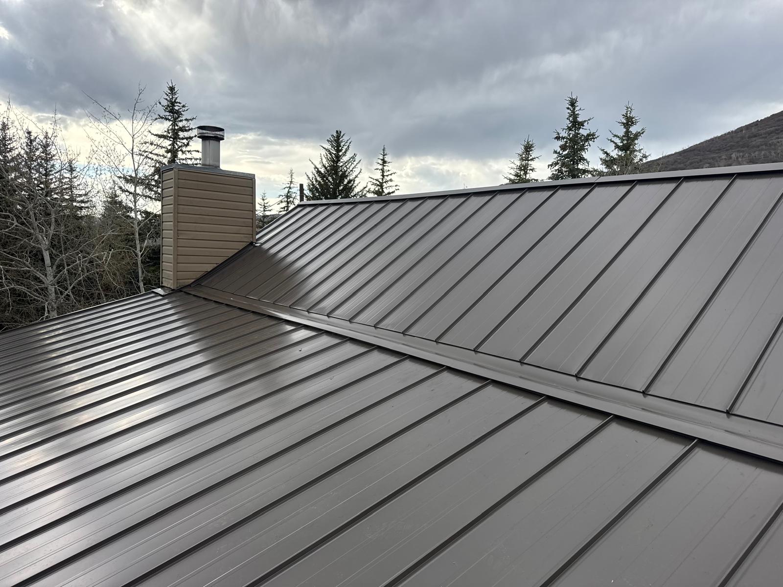 Completed metal standing seam roof with chimney